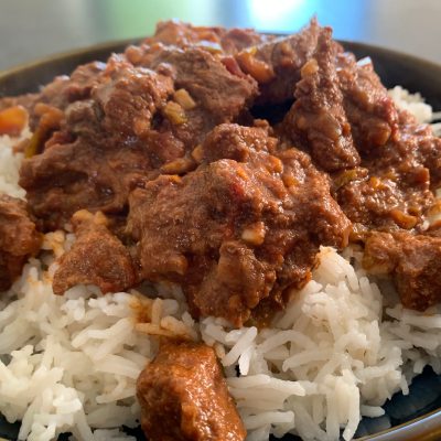 picture of a bowl of beef curry on a bed of rice