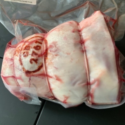 A bone in lamb leg joint by Red Down Beef and Lamb on a black background.