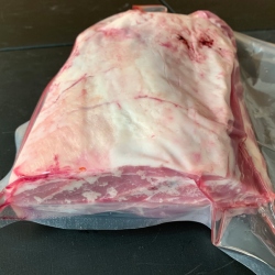 A bone in shoulder of lamb from Red Down Beef and Lamb on a black background.